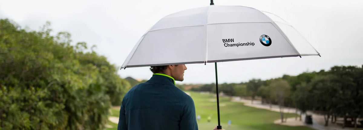 Man holding a BMW Championship umbrella