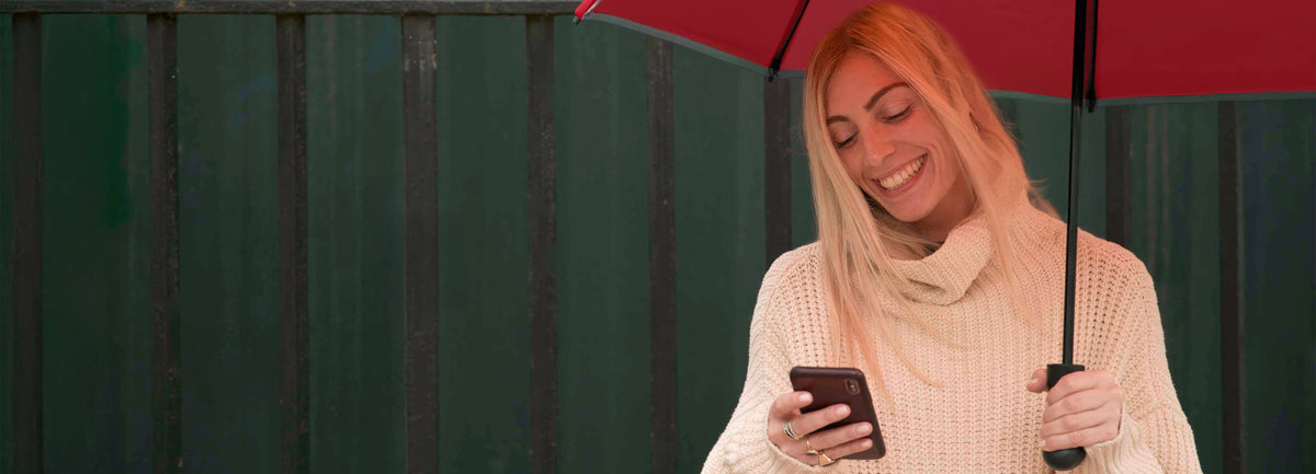 A woman smiles while holding a red umbrella