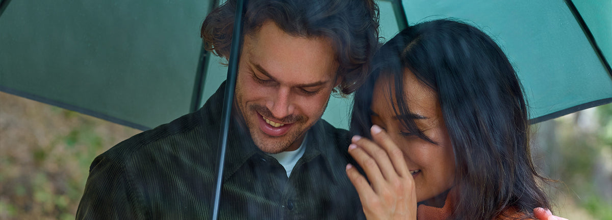 Man holding the umbrella with a woman beside him