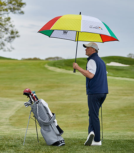 Man with an Arnold Palmer umbrella on a golf course